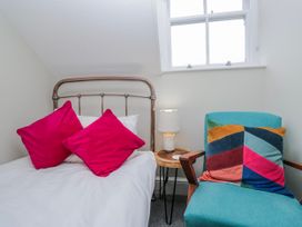 A bedroom with a bed and chair at The Thistles Bowness-On-Windermere