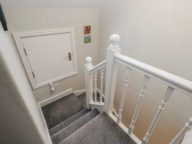 A staircase with a door and paintings at The Thistles in Bowness-On-Windermere