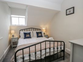 A bedroom with a bed nightstand and dresser at The Thistles Bowness-On-Windermere
