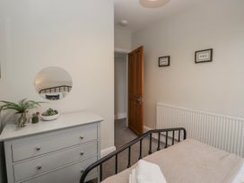 A bedroom with a bed and a dresser at The Thistles in Bowness-On-Windermere