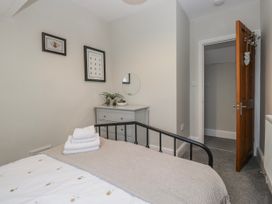 A bedroom with a bed and dresser at The Thistles in Bowness-On-Windermere