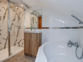 A bathroom with a shower, bathtub, and sink at The Thistles in Bowness-On-Windermere