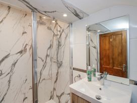 A bathroom with a shower and sink at The Thistles Bowness-On-Windermere