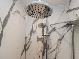 A shower with a large and handheld showerhead at The Thistles Bowness-On-Windermere