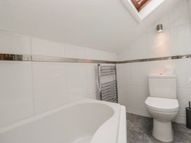 A bathroom with a bathtub and a toilet at The Thistles Bowness-On-Windermere