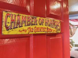 A red door with a yellow sign reading Chamber of Horrors The Greatest Show at Circus Circus in Holywell