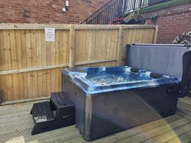 A hot tub with steps next to a wooden fence at Circus Circus, Holywell
