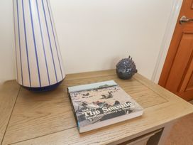 A living room with a lamp, book, and ornament at Jolly Roger in Whitby