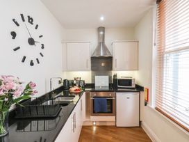 A kitchen with appliances and a clock at Jolly Roger in Whitby