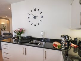 A kitchen with a sink and clock at Jolly Roger in Whitby