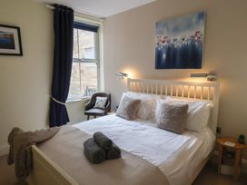 A bedroom with a bed and bedside table at Jolly Roger in Whitby