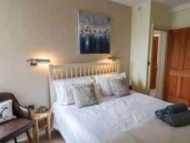 A bedroom with a bed and chair at Jolly Roger in Whitby