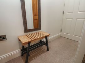 A hallway with a bench and a mirror at Jolly Roger in Whitby