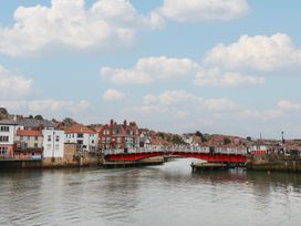 A view of the river with a bridge and buildings at Jolly Roger in Whitby