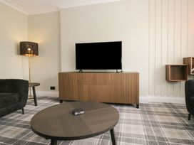A living room with a television and a lamp at 5 Thornbarrow Road