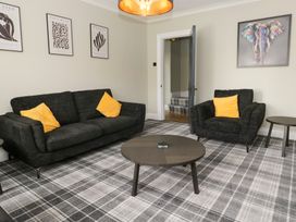 A living room with a sofa and armchair at 5 Thornbarrow Road