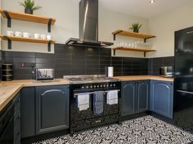A kitchen with cabinets and black appliances at 5 Thornbarrow Road in 