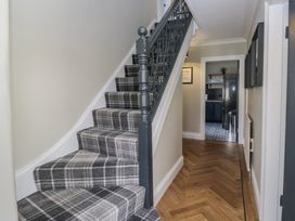 A hallway with a staircase and doorway at 5 Thornbarrow Road