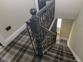A staircase with a handrail and patterned flooring at 5 Thornbarrow Road 