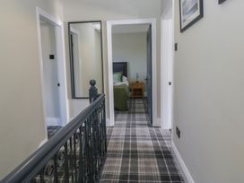 A hallway with doors and a mirror at 5 Thornbarrow Road