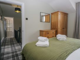 A bedroom with a bed and wooden furniture at 5 Thornbarrow Road