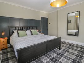 A bedroom with a bed and bedside tables at 5 Thornbarrow Road