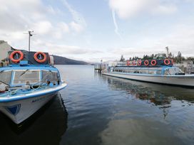 Two boats at a pier on a lake with lifebuoys at Miss Cumbria