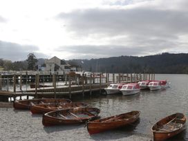 Wooden and motorboats at a pier with a building in the background at 5 Thornbarrow Road