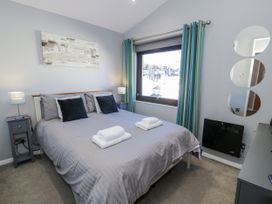 A bedroom with a bed and bedside tables at Estuary Escape in Porthmadog