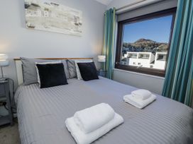 A bedroom with a bed and window view at Estuary Escape in Porthmadog