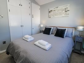 A bedroom with a bed and nightstands at Estuary Escape in Porthmadog