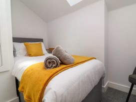 A bedroom with a single bed a yellow pillow a yellow blanket and rolled towels at Ladybird Rest in Parkham near Bideford