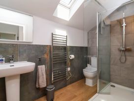 A bathroom with a sink and mirror towel rack toilet and shower at Ladybird Rest in Parkham near Bideford
