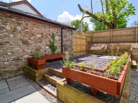A garden area with raised wooden planters and a stone wall at Ladybird Rest in Parkham near Bideford