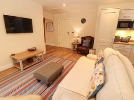 A living room with a sofa and television at Deer Wood At Applethwaite Hall in Windermere