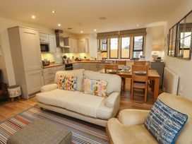 A kitchen with a sofa and dining table at Deer Wood At Applethwaite Hall in Windermere