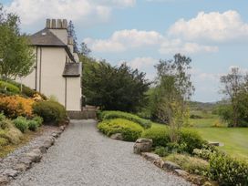 A garden with a gravel path and a house at Deer Wood At Applethwaite Hall in Windermere