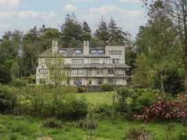 A house with multiple windows and surrounding garden at Deer Wood At Applethwaite Hall in Windermere