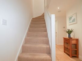 A hallway with stairs and a table at Blissful Ocean Breeze in Perranporth