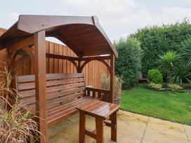 A bench and table in a garden at Blissful Ocean Breeze in Perranporth