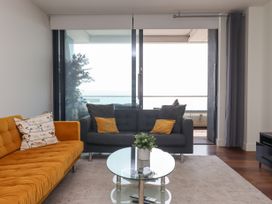A living room with a yellow sofa a gray sofa and a glass coffee table at Apartment 17 Abbey Sands in Torquay