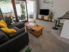 A living room with a sofa and television at Lake View in Swanpool, Nr Falmouth