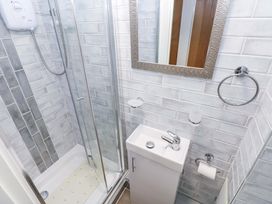 A bathroom with a shower, sink, and mirror at 3 Devon Court in Pembroke