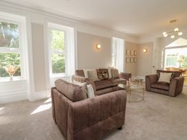 A living room with brown sofas and a glass coffee table at Serenity House The Retreat in Llangammarch Wells near Llanwrtyd Wells