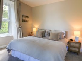 A bedroom with a double bed two bedside tables two lamps and a window at Serenity House The Retreat Llangammarch Wells near Llanwrtyd Wells