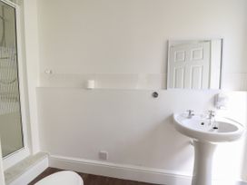 A bathroom with a pedestal sink a mirror a toilet and a shower enclosure at Serenity House The Retreat in Llangammarch Wells near Llanwrtyd Wells
