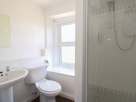 A bathroom with a sink, toilet, window, and shower at Serenity House The Retreat in Llangammarch Wells near Llanwrtyd Wells