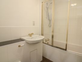 A bathroom with a sink and a bathtub with a shower at Serenity House The Retreat in Llangammarch Wells near Llanwrtyd Wells