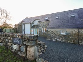 A stone house with a gravel driveway at Llys Bennar in Dyffryn Ardudwy