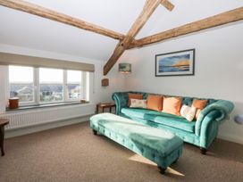 A living room with a sofa and footstool at Yr Hen Felin in Dyffryn Ardudwy